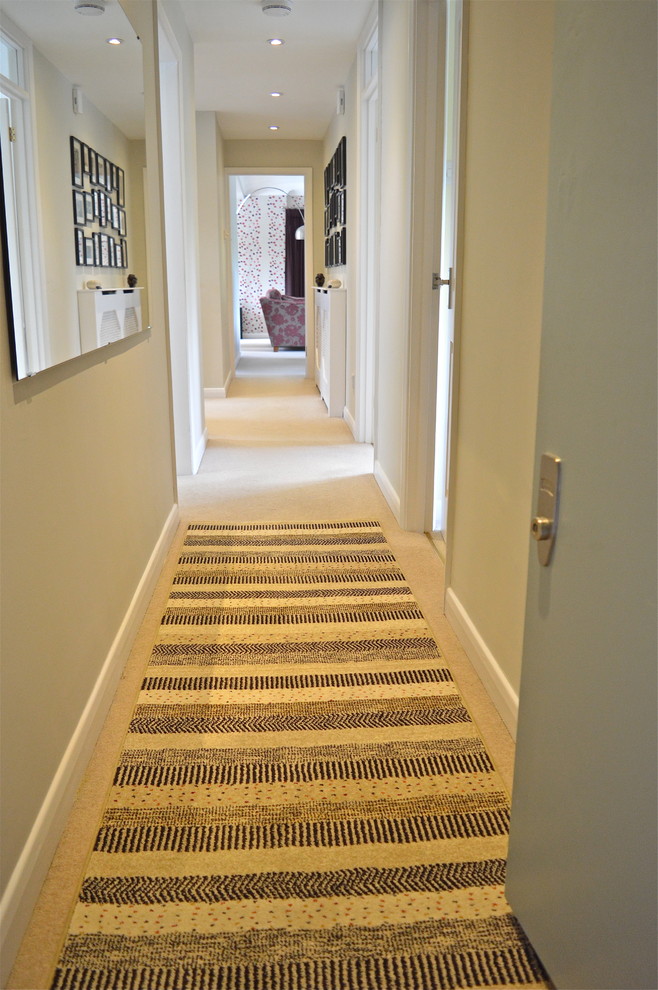Inspiration for a contemporary hallway in London with beige walls and carpet.