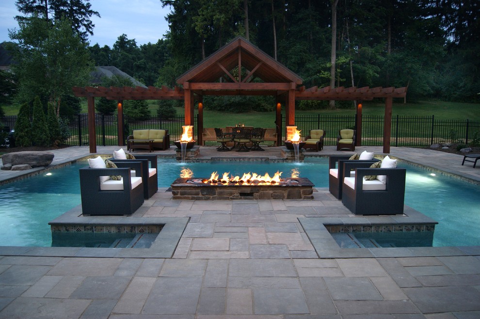 Design ideas for an expansive contemporary backyard custom-shaped pool in Other with concrete pavers.