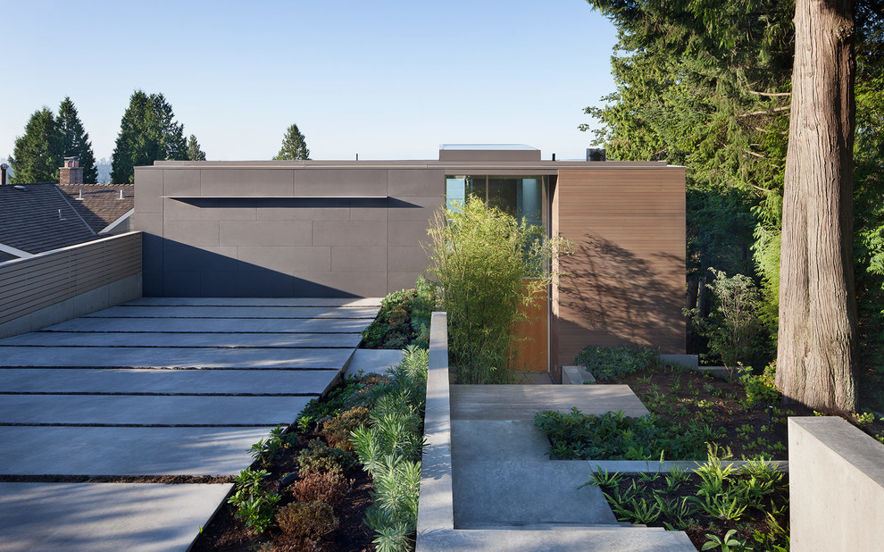 Photo of a modern three-storey exterior in Vancouver with wood siding and a flat roof.
