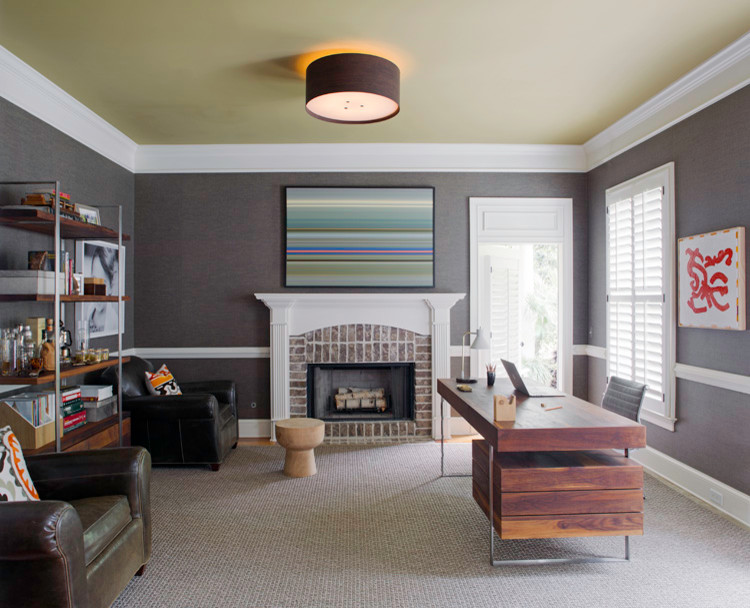 This is an example of a mid-sized contemporary study room in Atlanta with grey walls, carpet, a standard fireplace, a brick fireplace surround and a freestanding desk.
