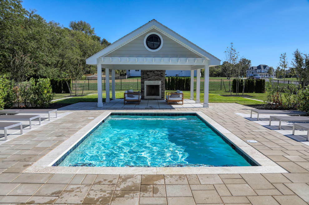 Small modern backyard rectangular pool in Other with natural stone pavers.