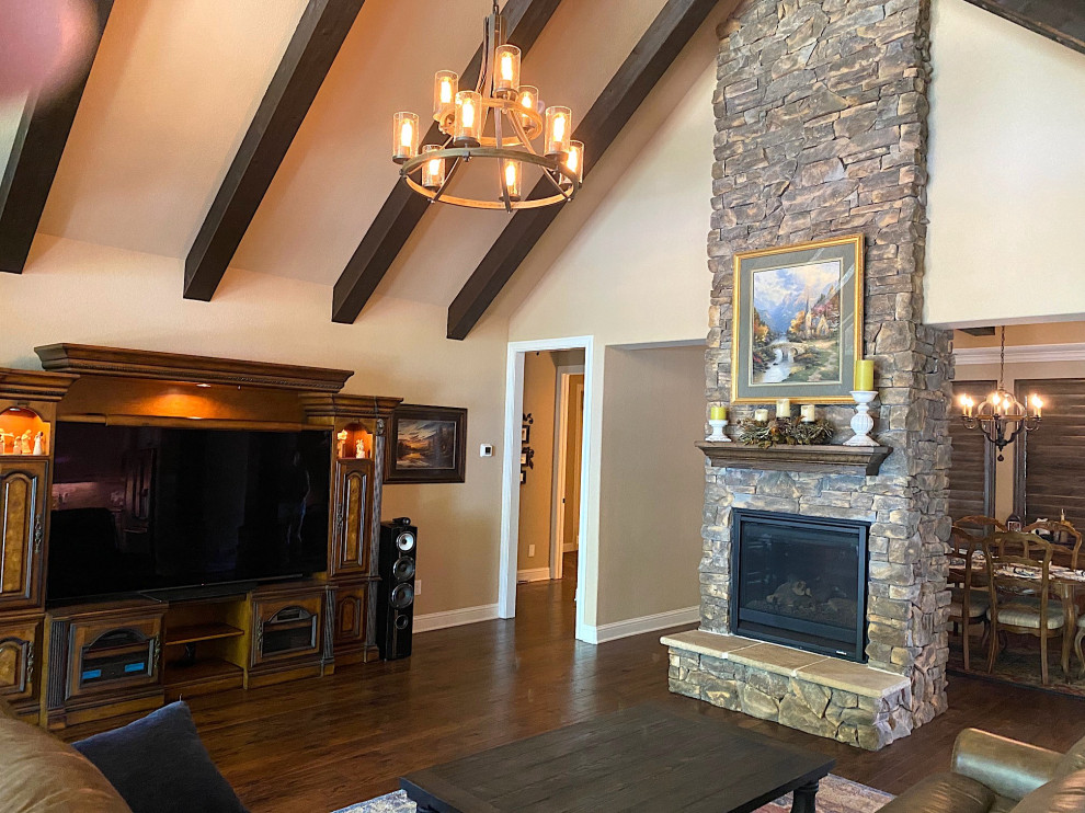 Inspiration for a mid-sized arts and crafts open concept living room in Dallas with brown walls, medium hardwood floors, a two-sided fireplace, a wall-mounted tv, brown floor and vaulted.