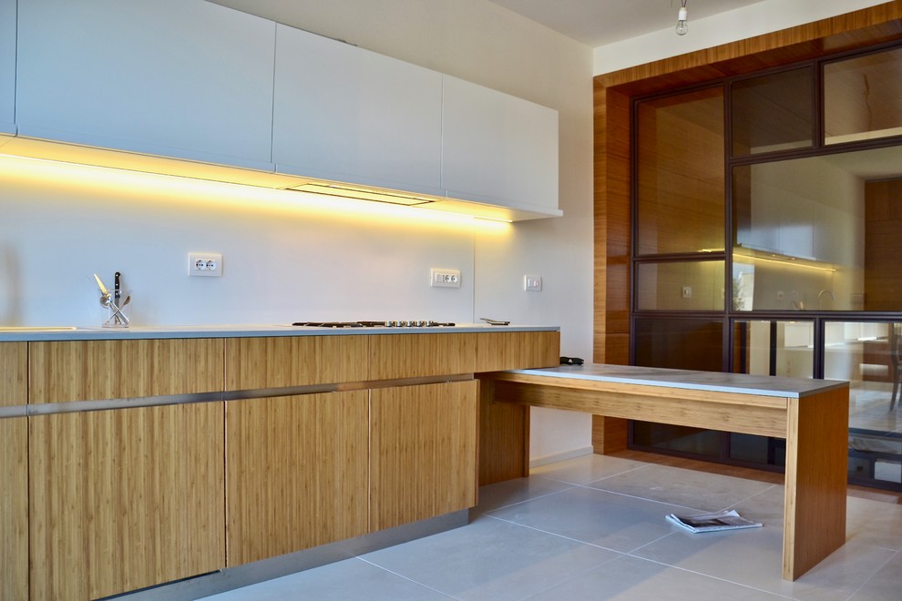 Inspiration for a large contemporary galley separate kitchen in Rome with a drop-in sink, flat-panel cabinets, white cabinets, concrete benchtops, white splashback, glass sheet splashback, stainless steel appliances, concrete floors, with island and white floor.