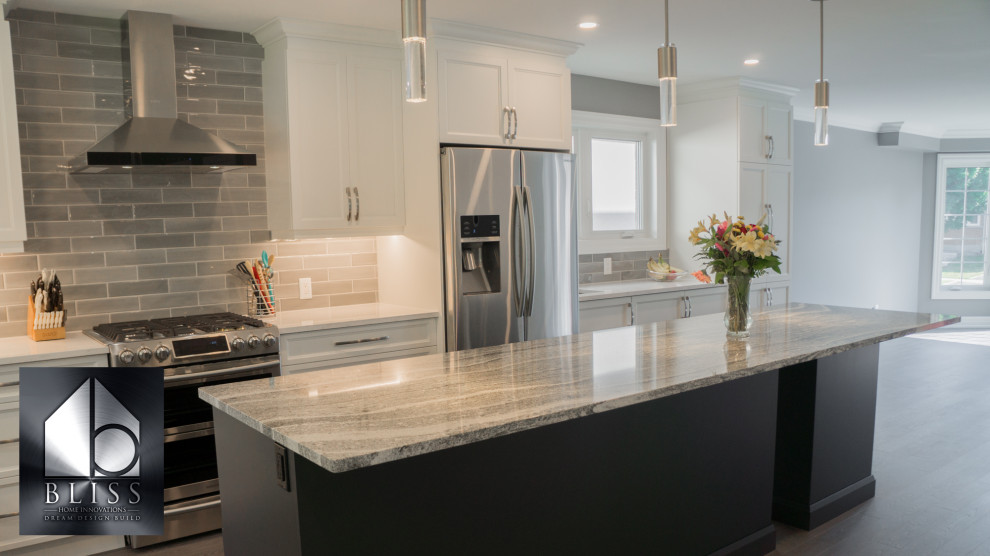 Inspiration for a large transitional gray floor and porcelain tile eat-in kitchen remodel in Toronto with an undermount sink, white cabinets, quartzite countertops, stainless steel appliances, an island, beaded inset cabinets, brick backsplash and white countertops