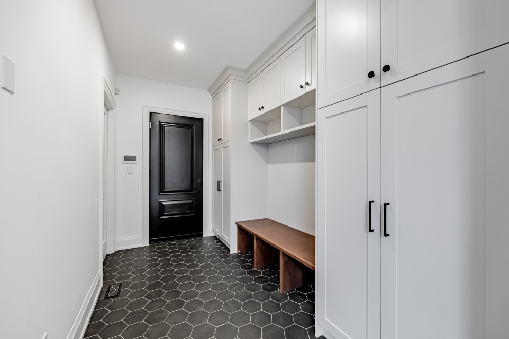 Стильный дизайн: большой тамбур в стиле кантри с белыми стенами, полом из керамической плитки, одностворчатой входной дверью, черной входной дверью и черным полом - последний тренд