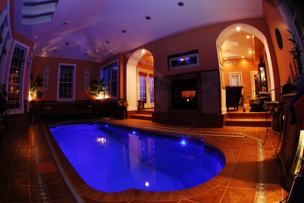 Small mediterranean indoor custom-shaped pool in Other with tile.