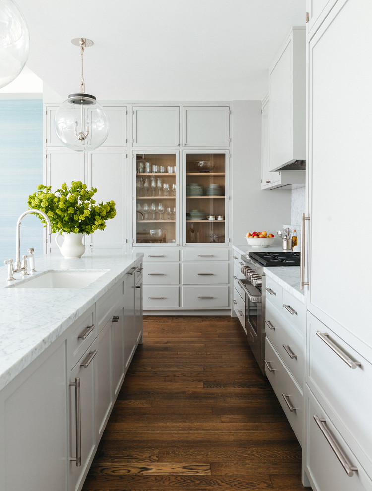 Design ideas for a mid-sized transitional kitchen in New York with with island, an undermount sink, glass-front cabinets, grey cabinets, stainless steel appliances and dark hardwood floors.