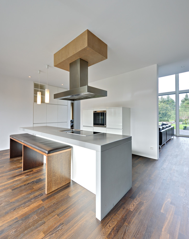 Inspiration for a large contemporary open plan kitchen in Berlin with with island, flat-panel cabinets, white cabinets, panelled appliances and dark hardwood floors.
