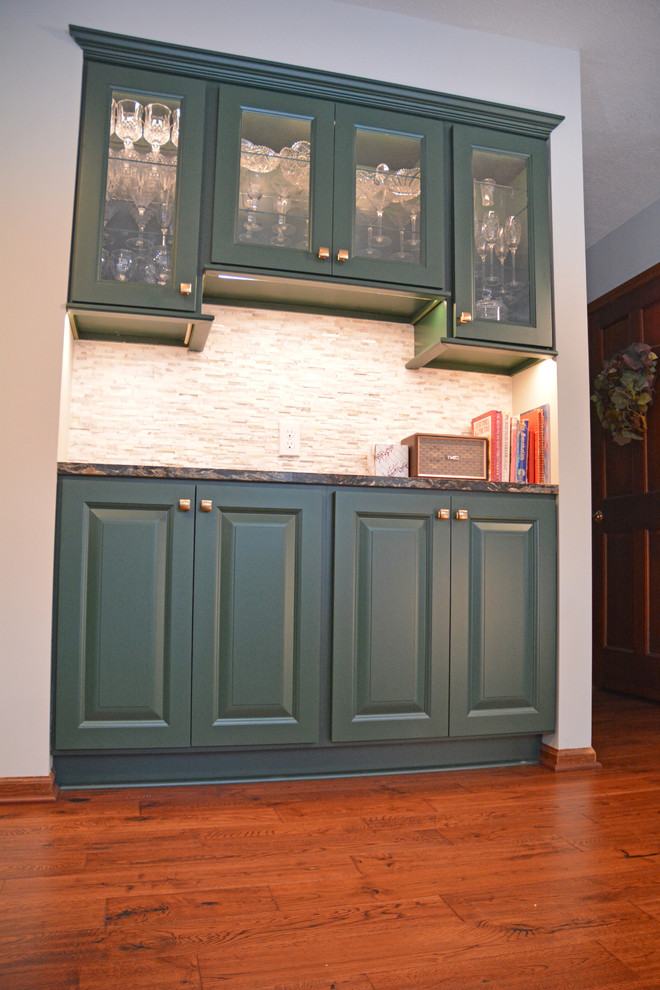 Example of a small transitional l-shaped medium tone wood floor and brown floor eat-in kitchen design with an undermount sink, raised-panel cabinets, green cabinets, quartz countertops, white backsplash, marble backsplash, black appliances, an island and multicolored countertops