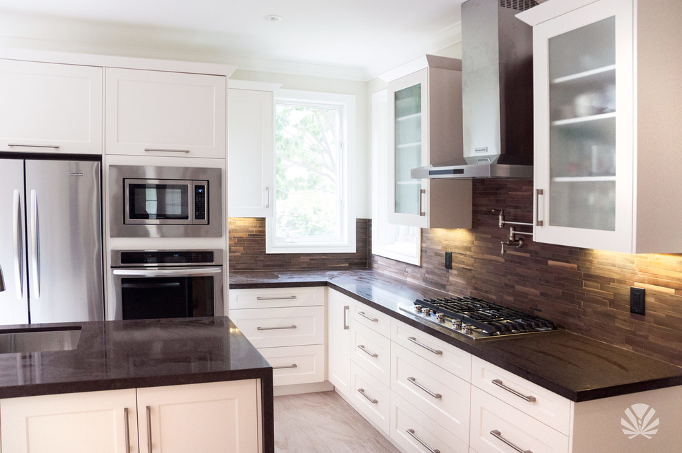 Mid-sized transitional l-shaped open plan kitchen in Toronto with an undermount sink, glass-front cabinets, white cabinets, quartzite benchtops, brown splashback, stone tile splashback, stainless steel appliances, ceramic floors and with island.