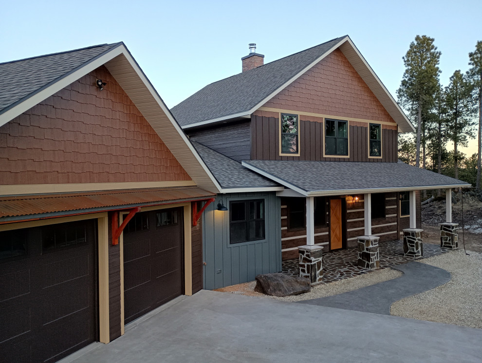 Inspiration for a rustic two-story mixed siding and board and batten exterior home remodel in Other with a shingle roof and a brown roof