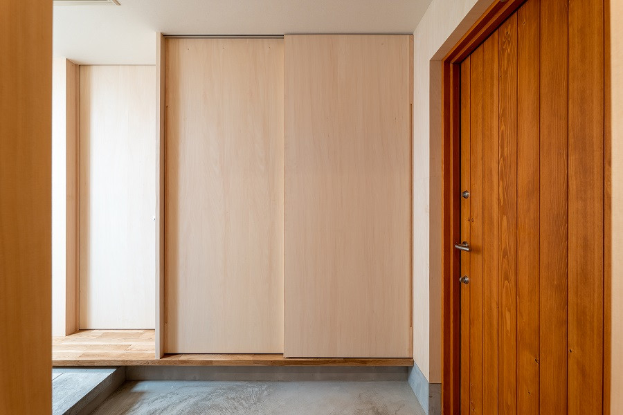 Medium sized scandi hallway in Tokyo Suburbs with beige walls, a single front door, a brown front door, grey floors, a wallpapered ceiling and wood walls.