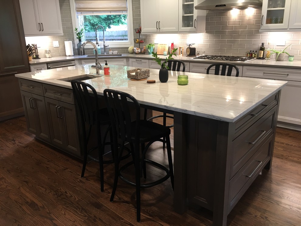 Large transitional u-shaped dark wood floor and brown floor open concept kitchen photo in Chicago with an undermount sink, flat-panel cabinets, white cabinets, quartz countertops, gray backsplash, ceramic backsplash, stainless steel appliances, an island and gray countertops