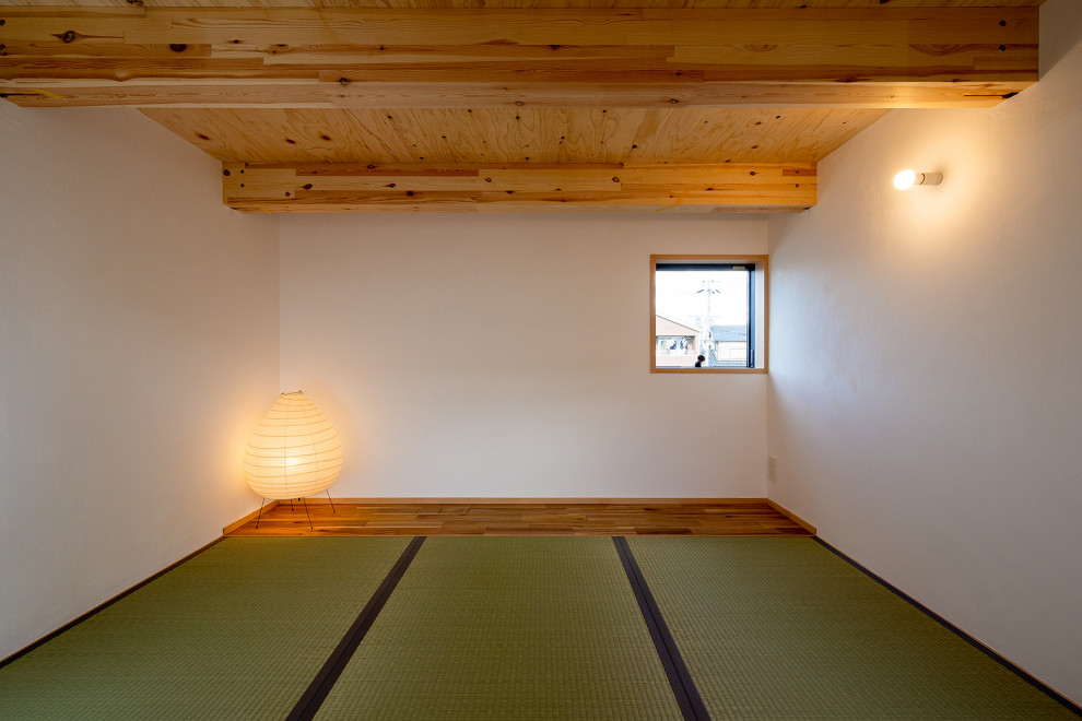 Kleines, Fernseherloses, Offenes Skandinavisches Wohnzimmer ohne Kamin mit weißer Wandfarbe, Tatami-Boden, grünem Boden, freigelegten Dachbalken und Tapetenwänden in Sonstige