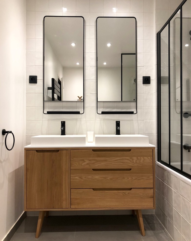 Photo of a contemporary bathroom in Paris with white tile, white walls, cement tiles, a console sink, grey floor, a shower/bathtub combo and porcelain tile.