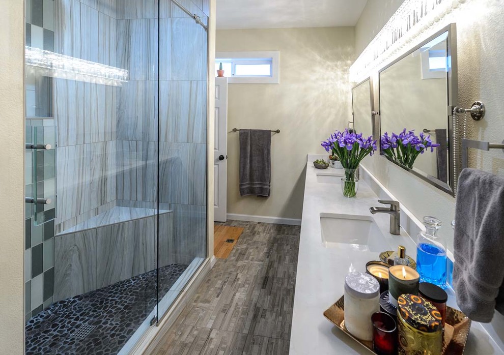 Design ideas for a mid-sized transitional master bathroom in Portland with an alcove shower, ceramic tile, beige walls, porcelain floors, an undermount sink, solid surface benchtops, grey floor, a hinged shower door, shaker cabinets, dark wood cabinets, a two-piece toilet and beige tile.