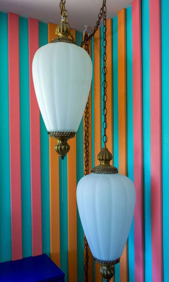 Ejemplo de salón cerrado exótico de tamaño medio con paredes azules, suelo de madera en tonos medios, televisor colgado en la pared, panelado y suelo rojo