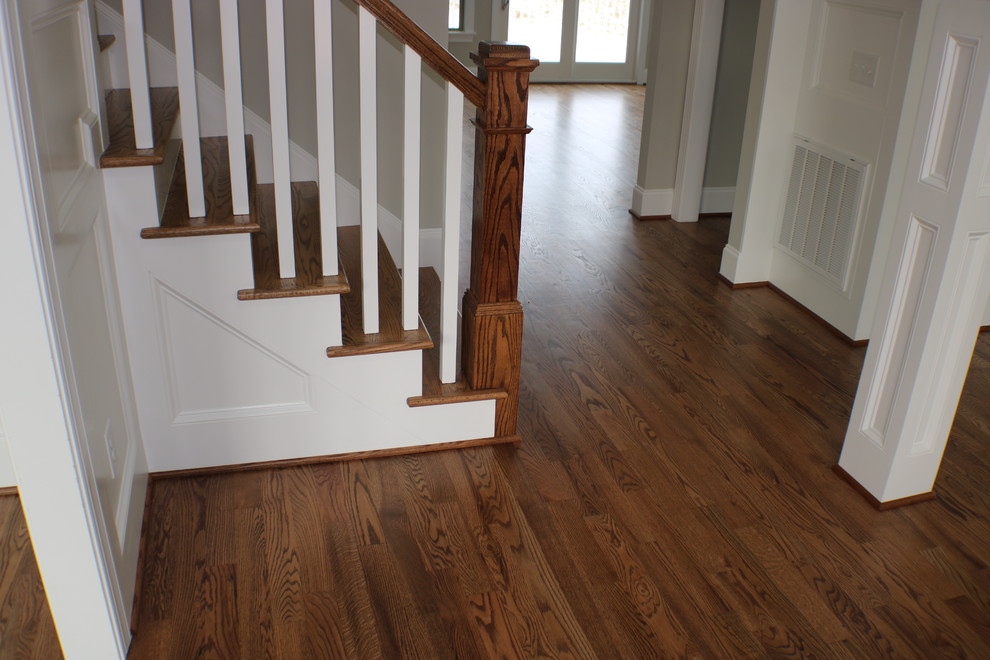 This is an example of a large traditional wood straight staircase in Raleigh with painted wood risers and wood railing.