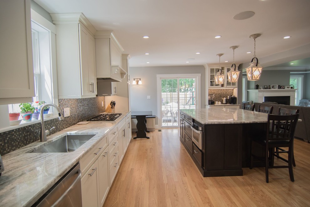 Design ideas for a large transitional u-shaped open plan kitchen in Boston with an undermount sink, shaker cabinets, dark wood cabinets, quartzite benchtops, brown splashback, glass tile splashback, stainless steel appliances, medium hardwood floors and with island.