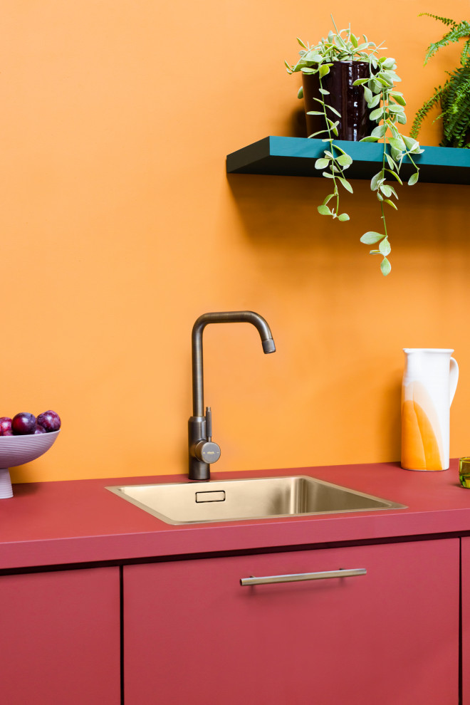 Exemple d'une petite cuisine ouverte linéaire moderne avec un évier 1 bac, un placard à porte plane, des portes de placard rouges, un plan de travail en bois, une crédence orange, une crédence en bois et un plan de travail rouge.