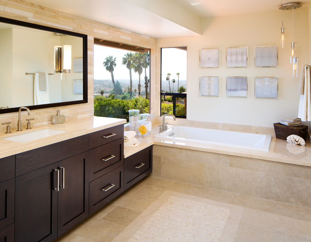 Large contemporary master bathroom in San Diego with an undermount sink, shaker cabinets, dark wood cabinets, marble benchtops, a drop-in tub, a corner shower, a one-piece toilet, beige tile, porcelain tile, beige walls and porcelain floors.