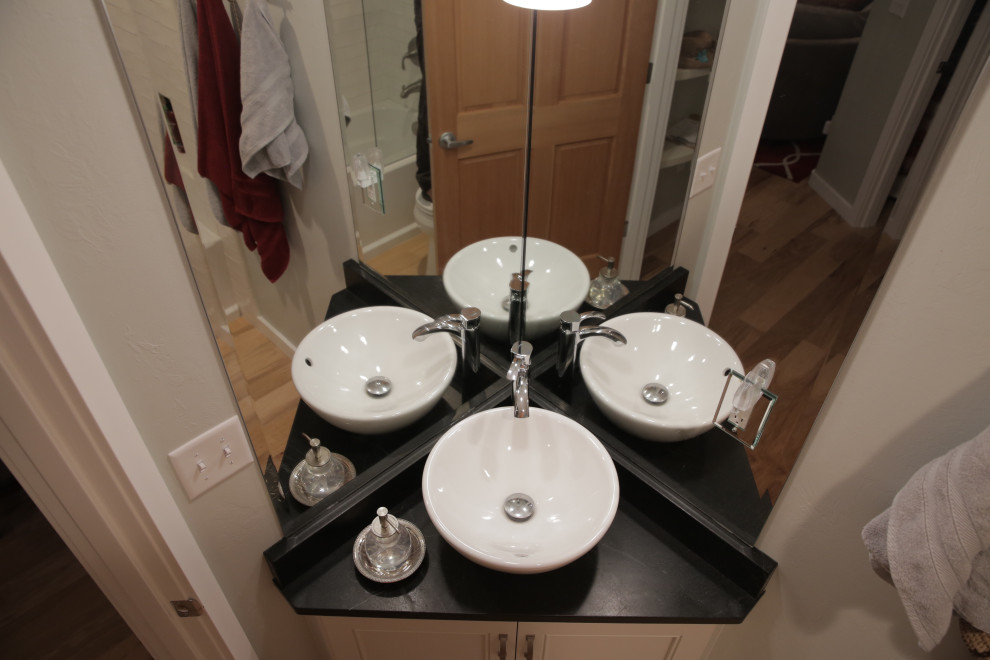 This is an example of a small eclectic bathroom in Other with recessed-panel cabinets, white cabinets, white walls, a pedestal sink, soapstone benchtops, black benchtops, a single vanity and a built-in vanity.
