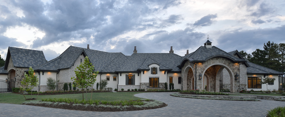 Design ideas for an expansive eclectic one-storey stucco beige house exterior in Houston with a hip roof and a tile roof.