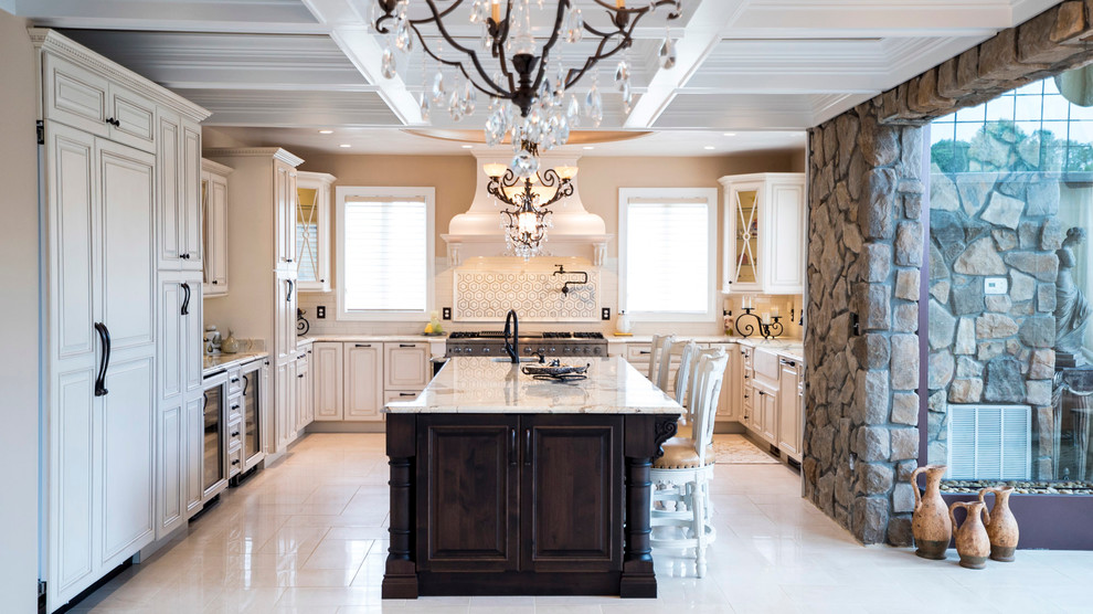 Inspiration for a large traditional u-shaped separate kitchen in DC Metro with a farmhouse sink, raised-panel cabinets, beige cabinets, granite benchtops, beige splashback, ceramic splashback, panelled appliances, with island, porcelain floors, beige floor, multi-coloured benchtop and coffered.