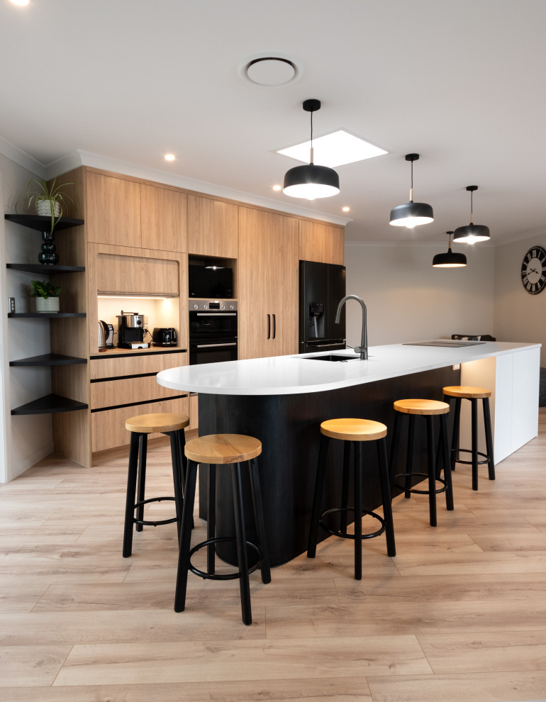 Photo of a medium sized modern kitchen/diner in Other with a submerged sink, light wood cabinets, engineered stone countertops, black appliances, laminate floors, an island and white worktops.