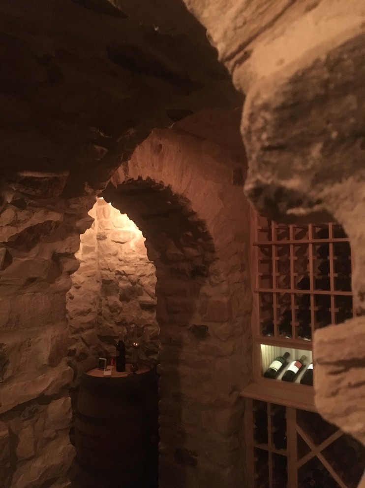 This is an example of a large traditional wine cellar in Cincinnati with concrete floors, storage racks and grey floor.