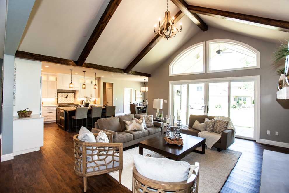 Photo of a large traditional open concept family room in Salt Lake City with beige walls, dark hardwood floors, a standard fireplace and brown floor.