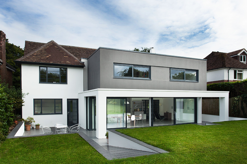 This is an example of a large contemporary split-level white exterior in Hampshire.