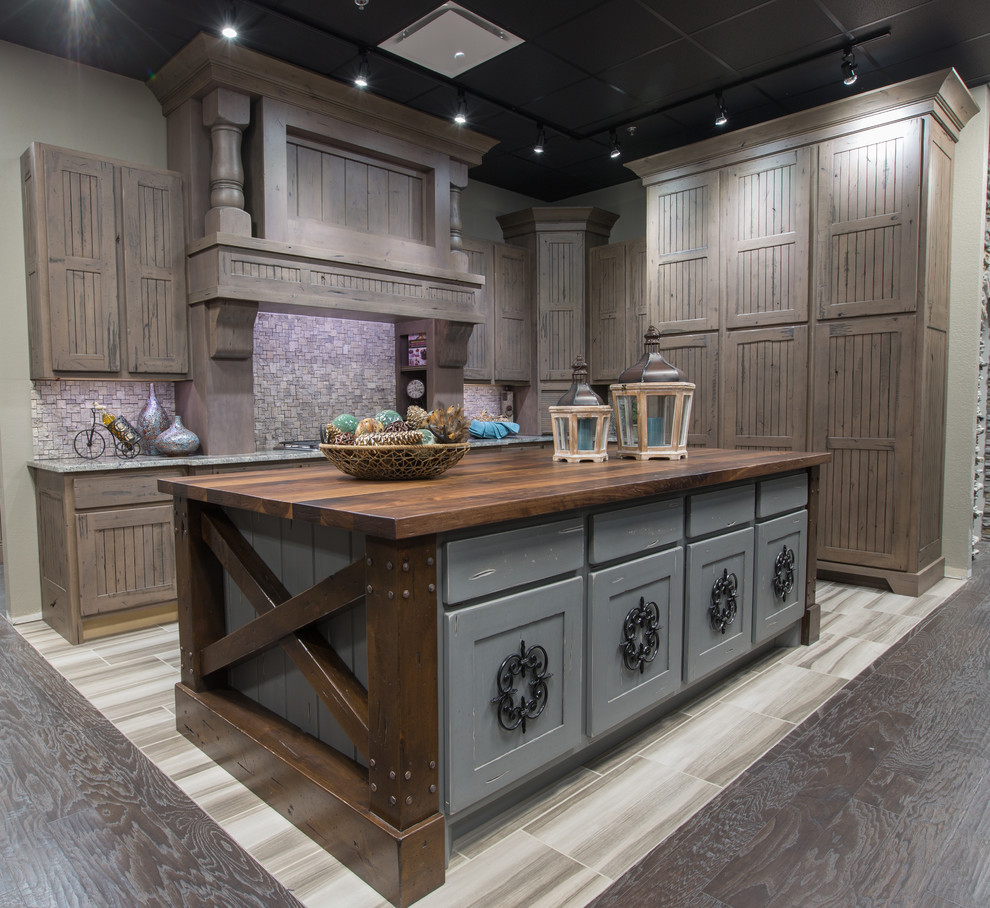 Enclosed kitchen - small rustic l-shaped porcelain tile and beige floor enclosed kitchen idea in Austin with distressed cabinets, gray backsplash, mosaic tile backsplash, paneled appliances, an island, an undermount sink, quartzite countertops, gray countertops and recessed-panel cabinets