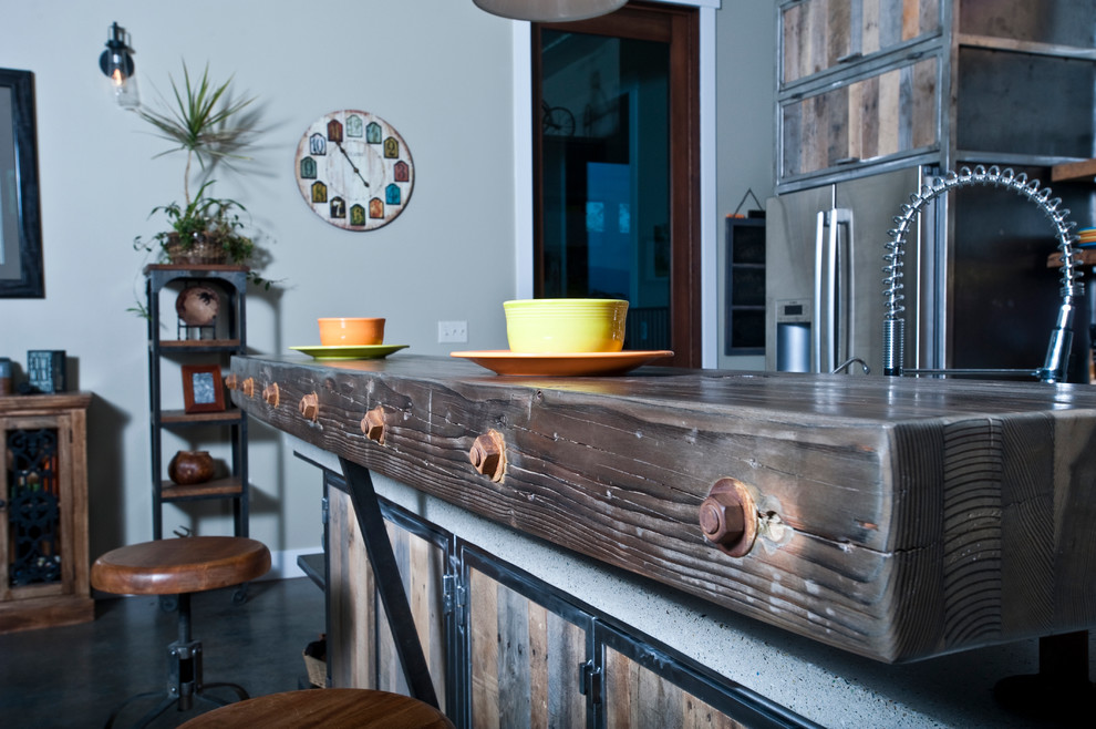 Design ideas for a large industrial galley open plan kitchen in Other with a double-bowl sink, distressed cabinets, recycled glass benchtops, metallic splashback, stainless steel appliances, concrete floors and with island.