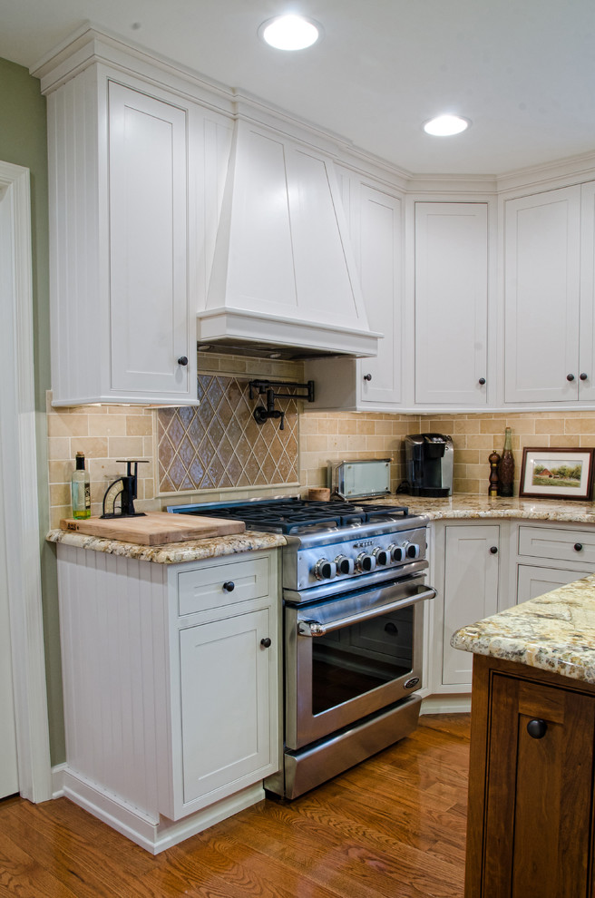 Inspiration for a traditional separate kitchen in Philadelphia with a farmhouse sink, beaded inset cabinets, white cabinets, granite benchtops, beige splashback, stainless steel appliances, medium hardwood floors and with island.