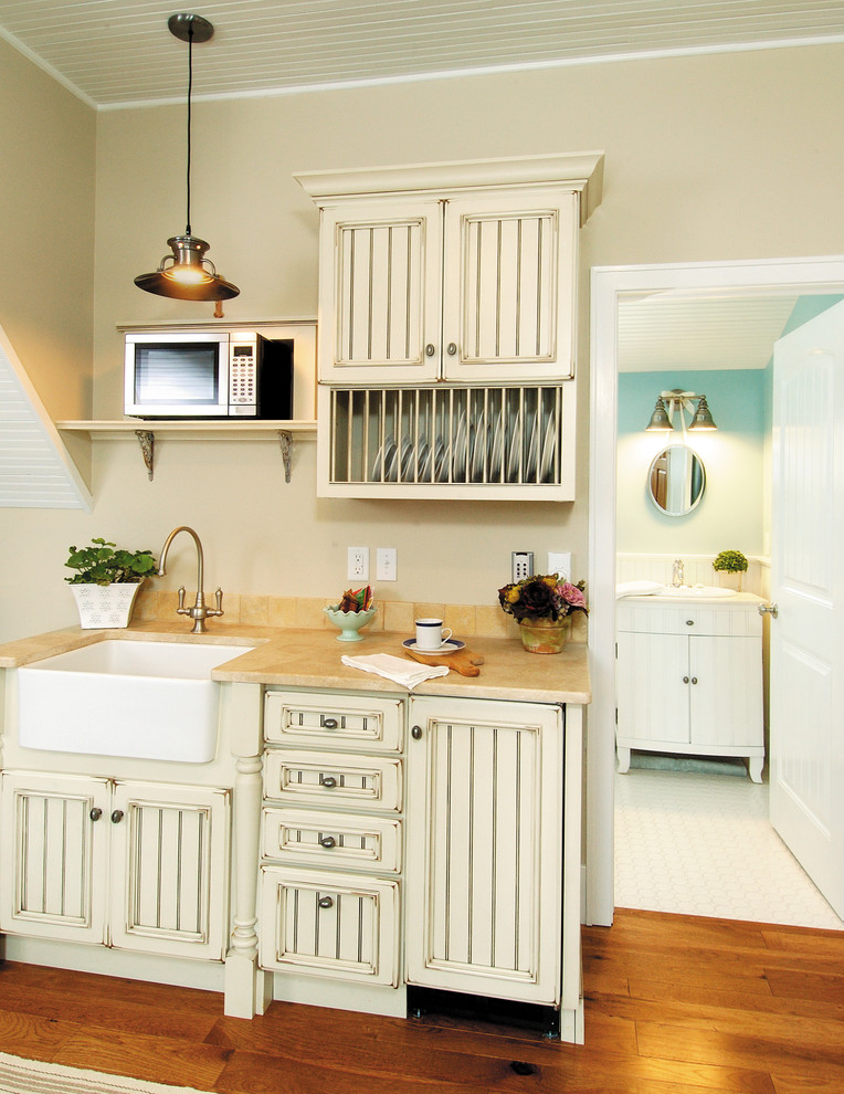 Inspiration for a small country single-wall eat-in kitchen in Other with a farmhouse sink, distressed cabinets, medium hardwood floors, recessed-panel cabinets, stainless steel appliances and no island.