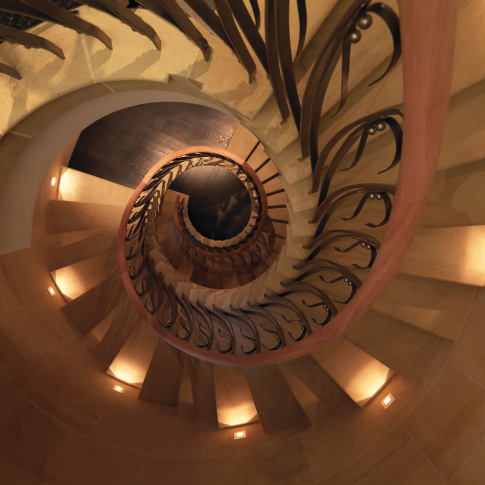 Photo of an expansive traditional limestone spiral staircase in Cheshire with metal railing and panelled walls.