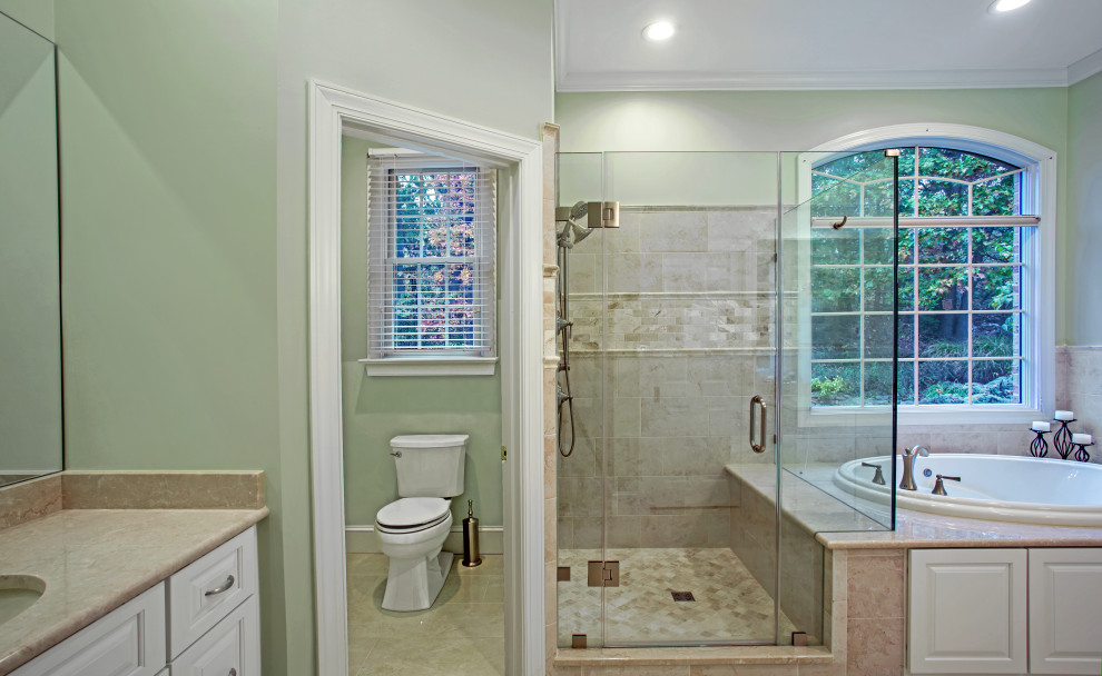 Inspiration for a medium sized classic ensuite bathroom in DC Metro with raised-panel cabinets, white cabinets, a built-in bath, a corner shower, a two-piece toilet, beige tiles, porcelain tiles, green walls, porcelain flooring, a submerged sink, marble worktops, beige floors, a hinged door, brown worktops, a shower bench, double sinks and a built in vanity unit.