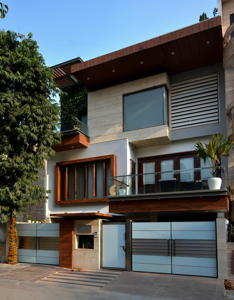 Contemporary three-storey exterior in Delhi with mixed siding and a flat roof.