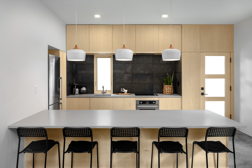 Inspiration for a small contemporary eat-in kitchen in Portland with an undermount sink, flat-panel cabinets, light wood cabinets, quartz benchtops, grey splashback, ceramic splashback, stainless steel appliances, concrete floors, a peninsula, grey floor and grey benchtop.
