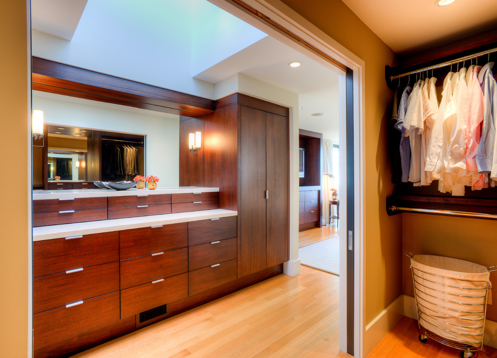 Photo of a mid-sized modern men's dressing room in Seattle with flat-panel cabinets, brown cabinets, medium hardwood floors and brown floor.