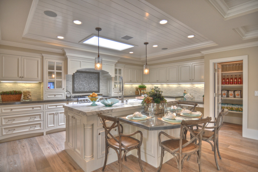 Inspiration for a beach style kitchen in Los Angeles with recessed-panel cabinets, white cabinets and beige splashback.