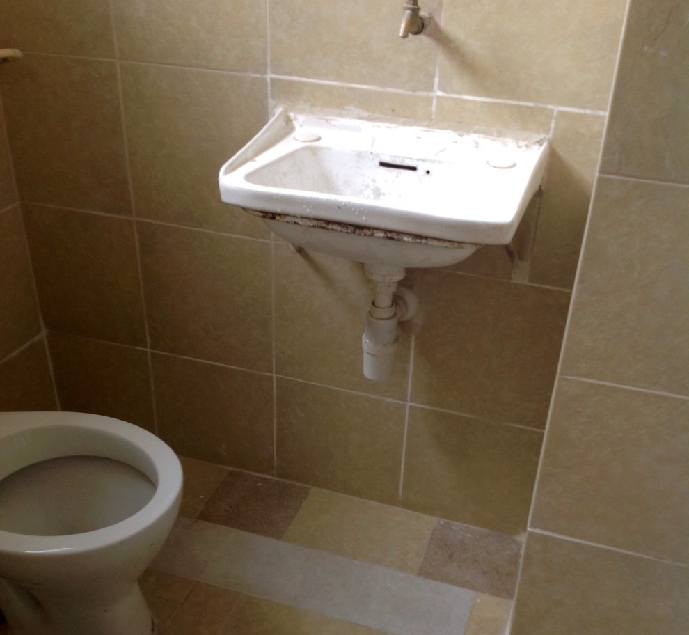 Inspiration for a rustic 3/4 beige tile and ceramic tile travertine floor bathroom remodel with a wall-mount sink and a two-piece toilet