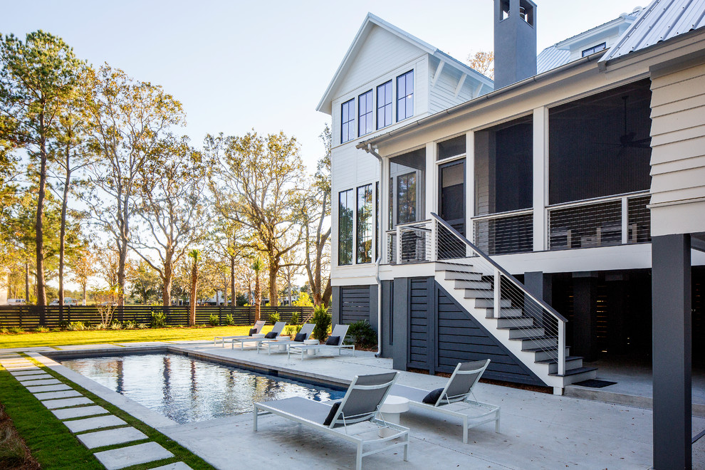 Photo of a large contemporary backyard rectangular pool in Charleston with a pool house and concrete pavers.