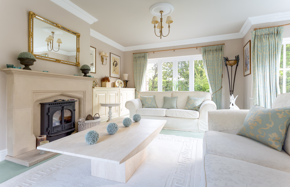 Photo of a large traditional formal enclosed living room in Hampshire with beige walls, carpet, a wood stove, a stone fireplace surround and a freestanding tv.