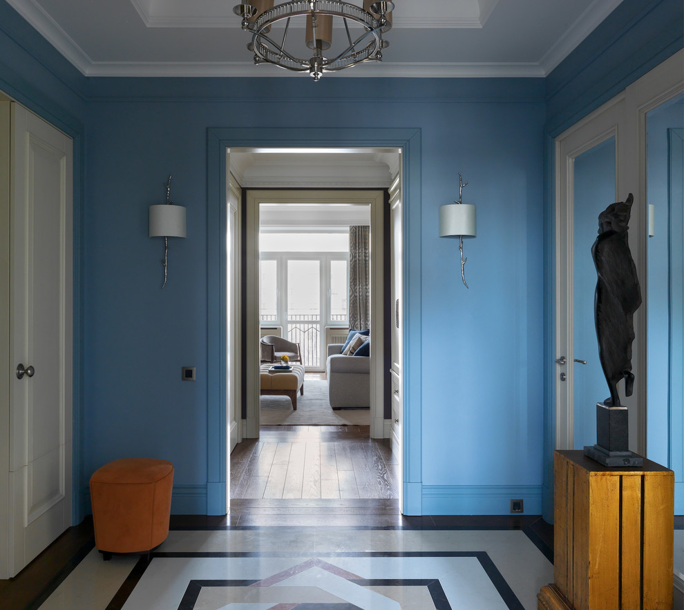 This is an example of a mid-sized transitional foyer in Moscow with blue walls, marble floors, a white front door and multi-coloured floor.