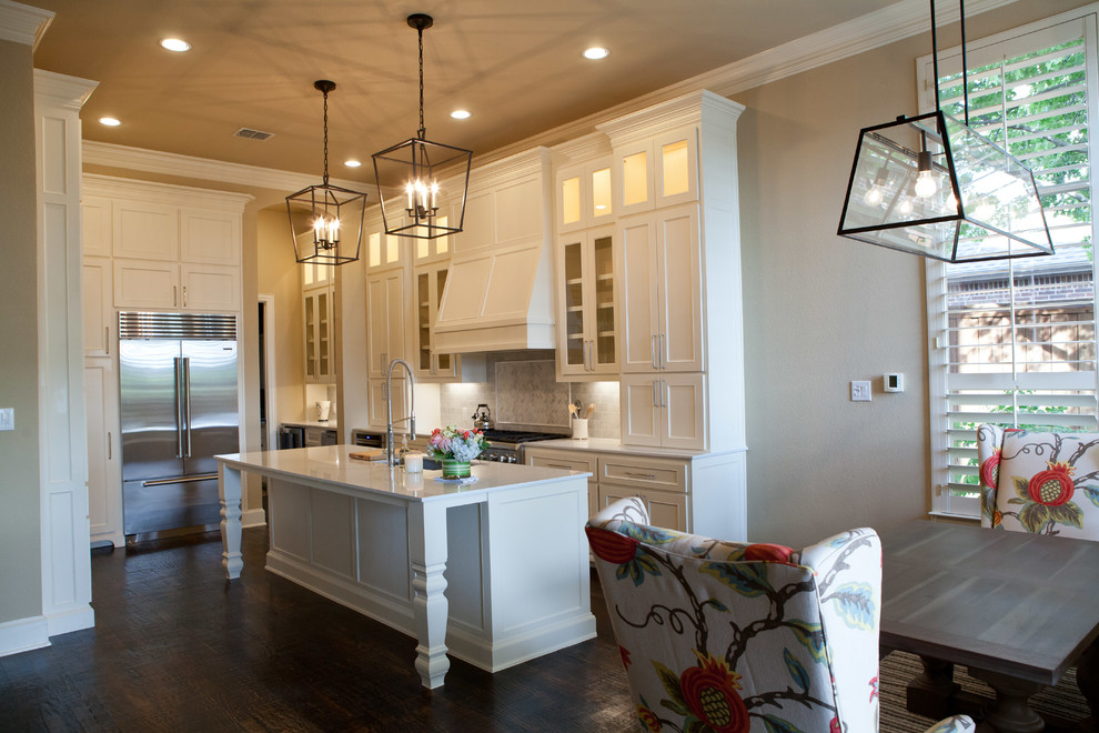 Inspiration for a large transitional galley dark wood floor and brown floor eat-in kitchen remodel in Dallas with a single-bowl sink, recessed-panel cabinets, white cabinets, quartz countertops, white backsplash, mosaic tile backsplash, stainless steel appliances and an island
