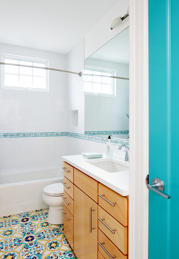 Inspiration for a transitional master bathroom in DC Metro with flat-panel cabinets, light wood cabinets, an alcove tub, a shower/bathtub combo, blue tile, white walls, mosaic tile floors, an undermount sink, multi-coloured floor, a shower curtain and white benchtops.