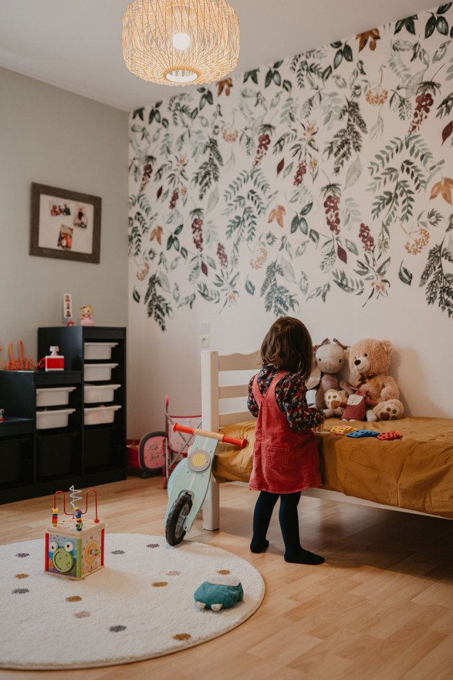 Bild på ett mellanstort lantligt flickrum kombinerat med sovrum och för 4-10-åringar, med gröna väggar och laminatgolv