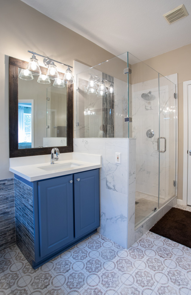 Design ideas for a large modern ensuite bathroom in Houston with raised-panel cabinets, blue cabinets, a freestanding bath, an alcove shower, a two-piece toilet, white tiles, glass tiles, yellow walls, ceramic flooring, a submerged sink, engineered stone worktops, brown floors, a hinged door, white worktops, a shower bench, double sinks and a freestanding vanity unit.